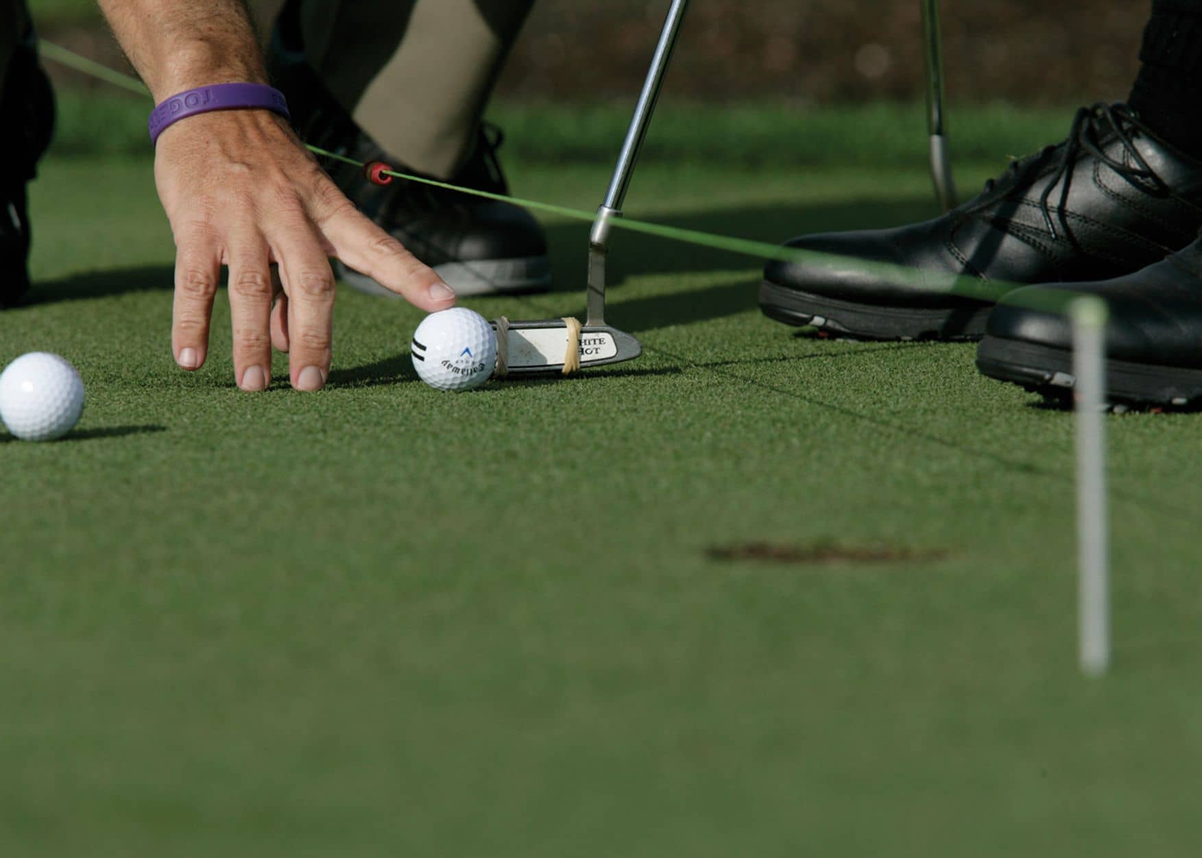 A man placing golf ball on ground at the Arnold Palmer Golf Academy