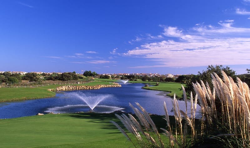 Le Cap D'agde Leadbetter Golf Academy green golf course area with pond decorated with sprinkles.