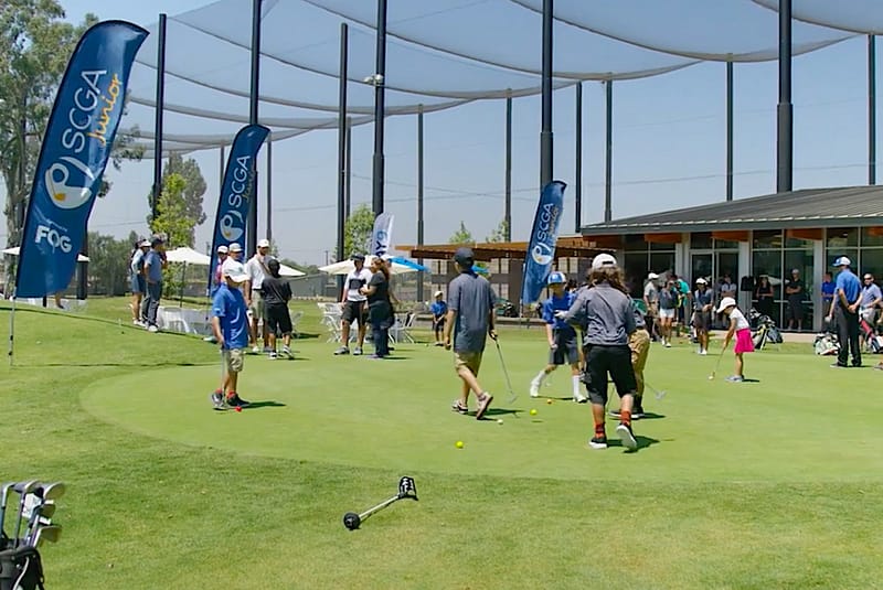 Junior golfers practicing at the golf course of Don Knabe Golf Center & Junior Academy
