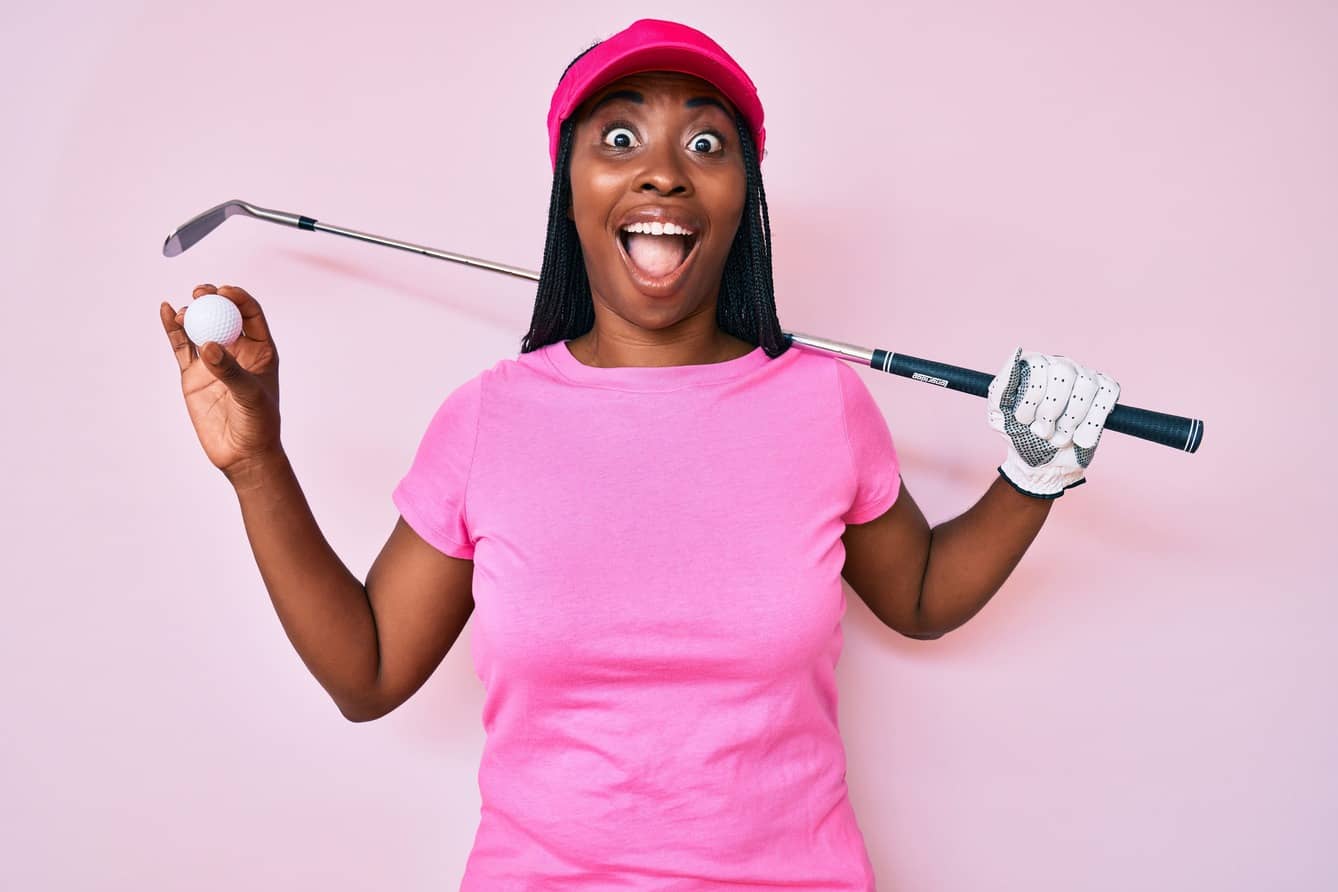 African american golfer woman with braids holding golf ball celebrating crazy and amazed for success with open eyes screaming excited.